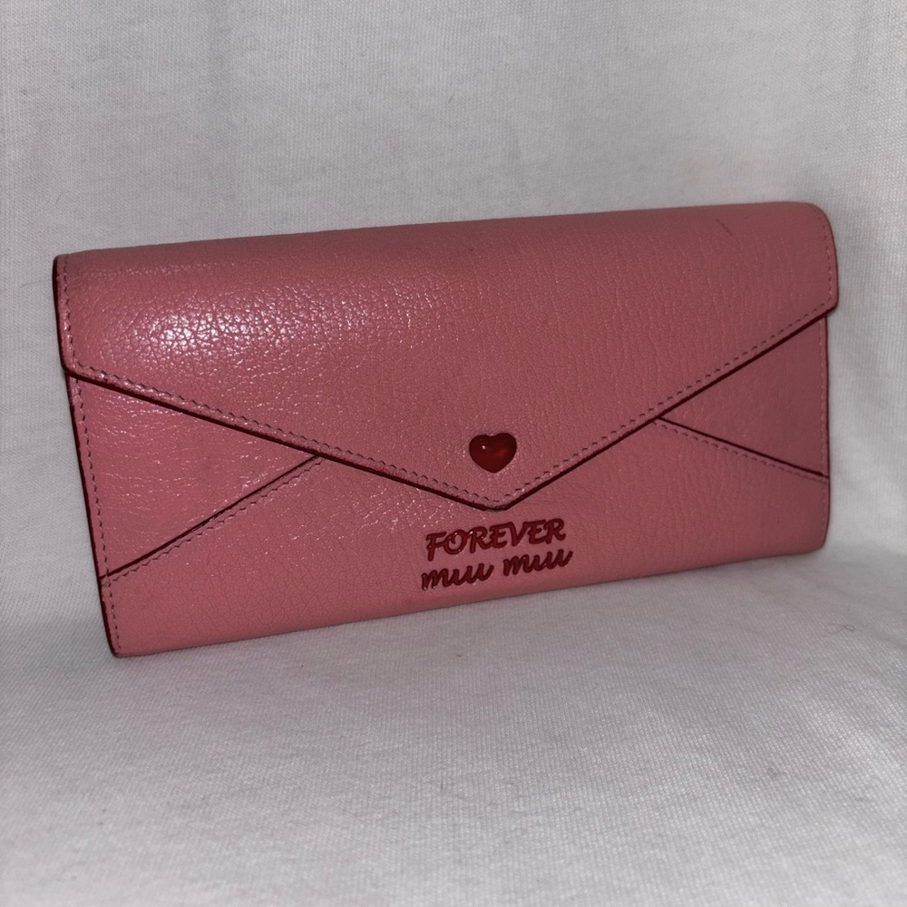 Long pink Miu Miu wallet with red lettering and metal snap button closure
